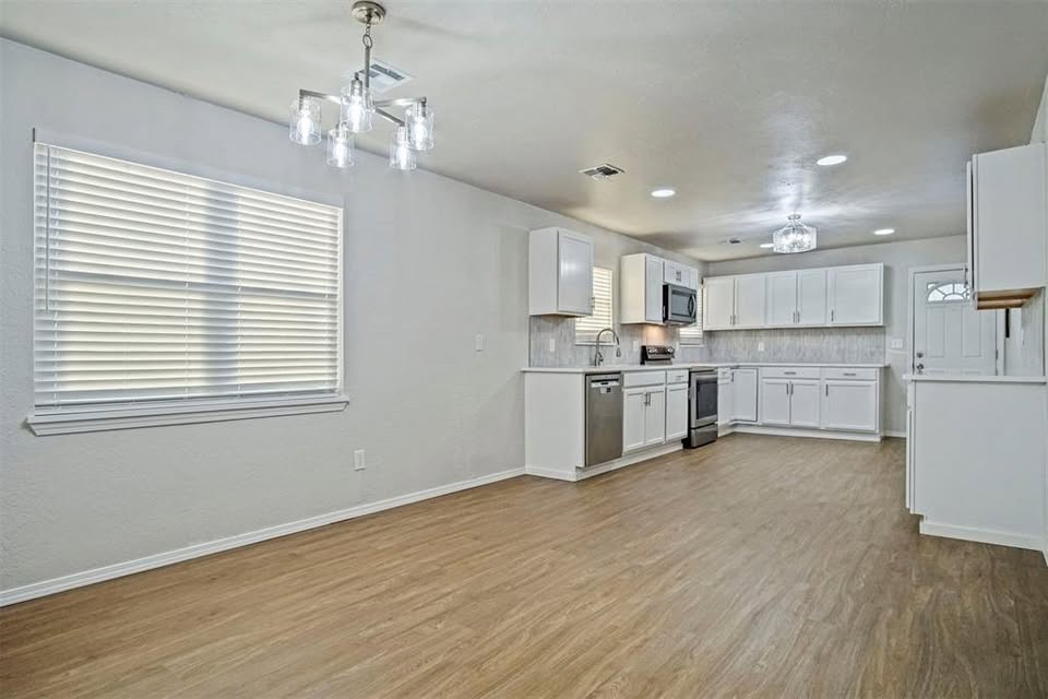 Tessa Hood Realtor – Open kitchen and dining area with wood floors at 1112 County Street 2910, Tuttle Oklahoma