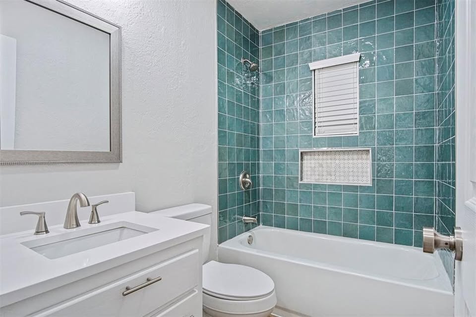 Tessa Hood Realtor – Bathroom with teal tile tub and shower combination at 1112 County Street 2910, Tuttle Oklahoma