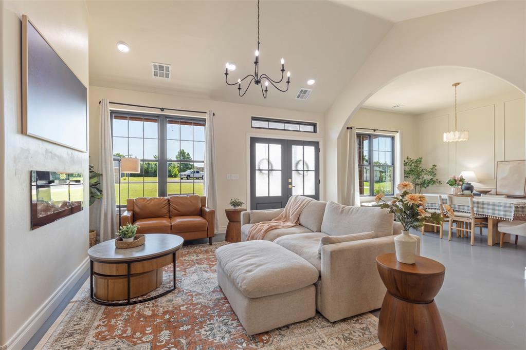 Tessa Hood Realtor – Open-concept living room with chandelier, large windows, and arched dining room entry at 1074 Fawn Meadow Dr, Blanchard Oklahoma