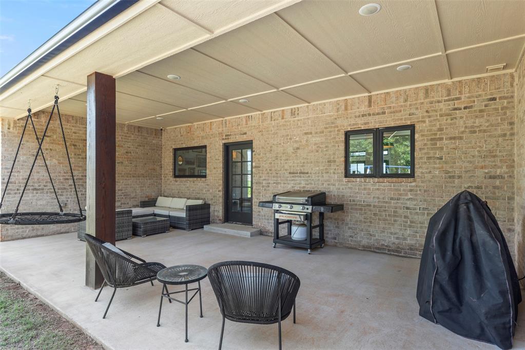Tessa Hood Realtor – Covered back patio with outdoor seating, swing chair, and gas grill at 1074 Fawn Meadow Dr, Blanchard Oklahoma