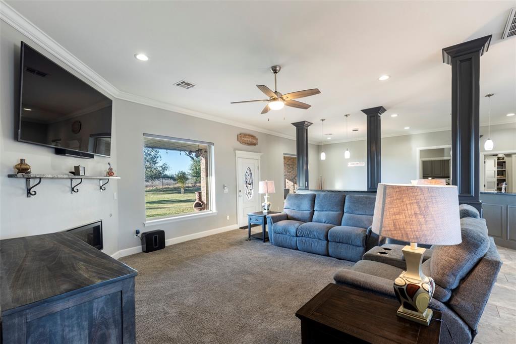 Tessa Hood Realtor – Living room with linear fireplace and open view to backyard at 516 Kings Ct, Tuttle Oklahoma