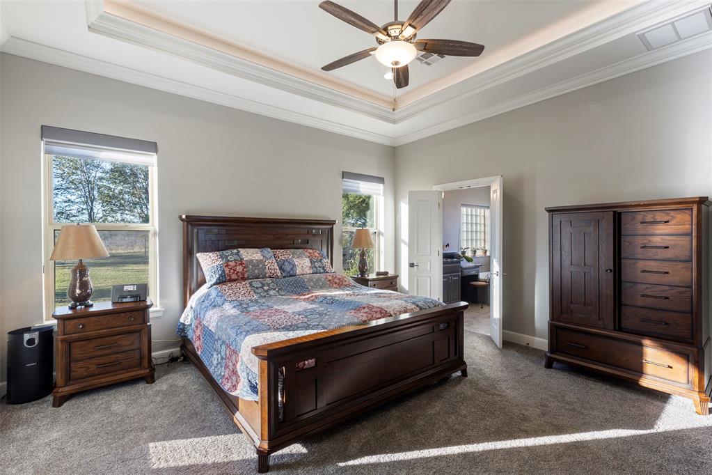 Tessa Hood Realtor – Master bedroom with tray ceiling and backyard views at 516 Kings Ct, Tuttle Oklahoma