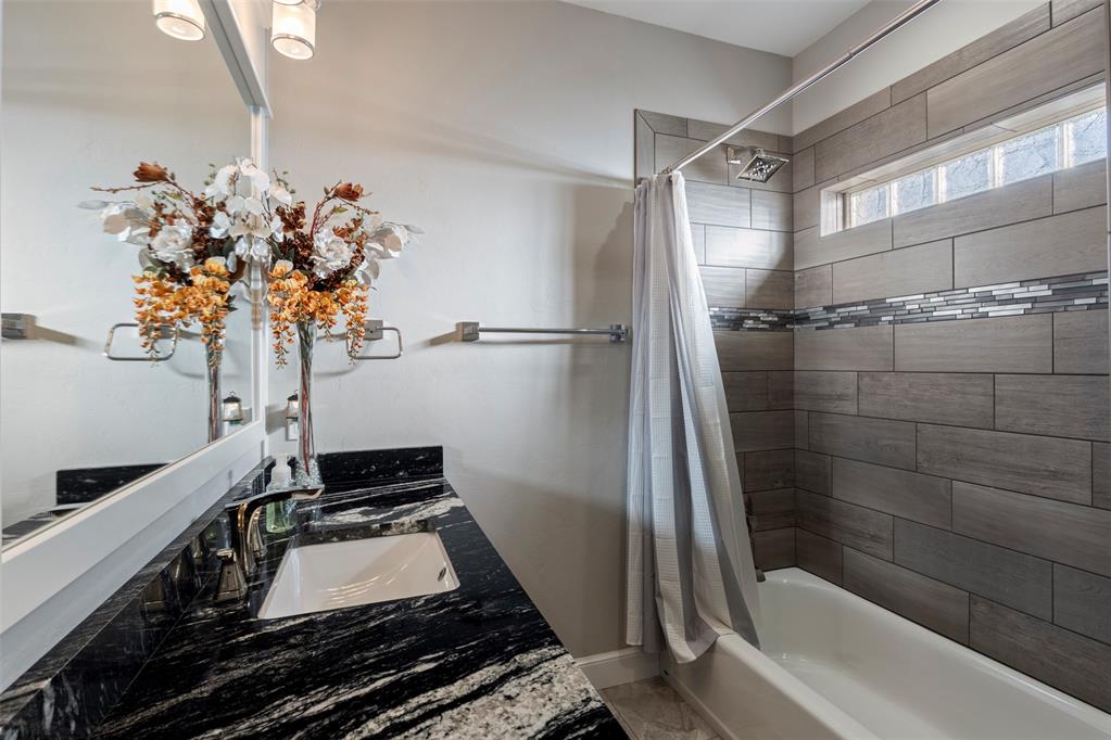 Tessa Hood Realtor – Secondary bathroom with granite vanity and tiled tub-shower at 516 Kings Ct, Tuttle Oklahoma