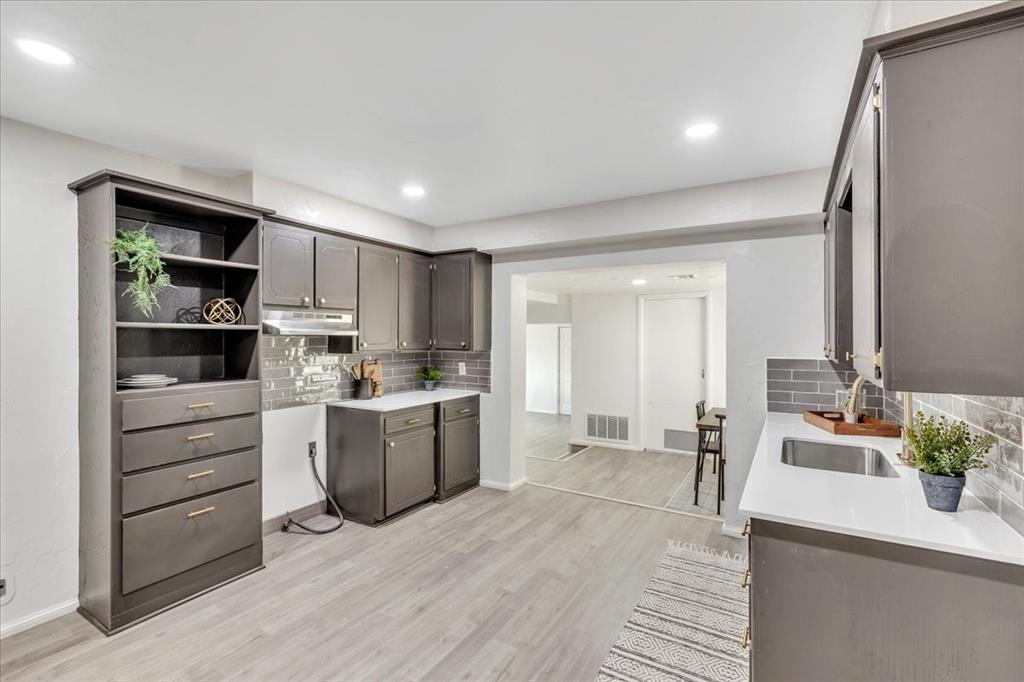 Tessa Hood Realtor – Updated kitchen with dark grey cabinetry, open shelving, and white quartz counters at 7400 Lakewood Dr, Mustang Oklahoma