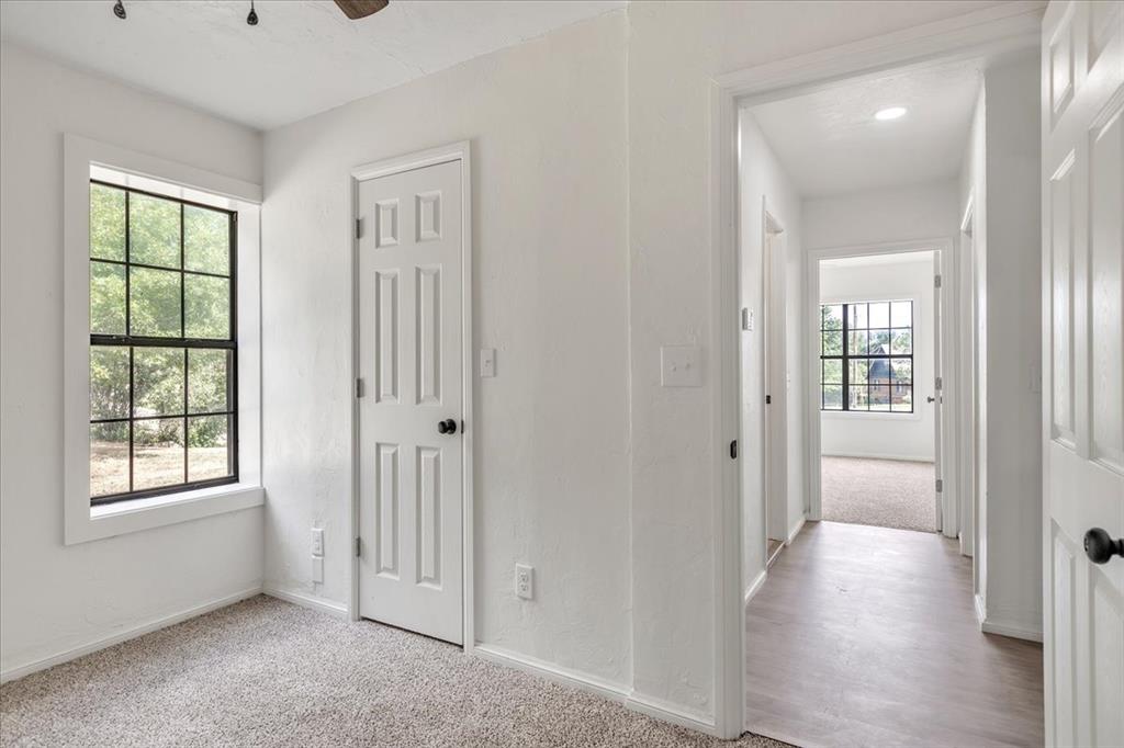 Tessa Hood Realtor – Secondary bedroom with window and hallway view at 7400 Lakewood Dr, Mustang Oklahoma