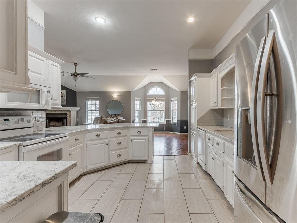Tessa Hood Realtor – Kitchen alternate view with stainless refrigerator and open to living room at 5879 Mockingbird Ln, Blanchard Oklahoma