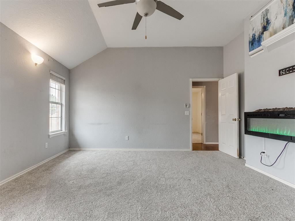 Tessa Hood Realtor – Primary bedroom with vaulted ceiling and electric fireplace at 5879 Mockingbird Ln, Blanchard Oklahoma