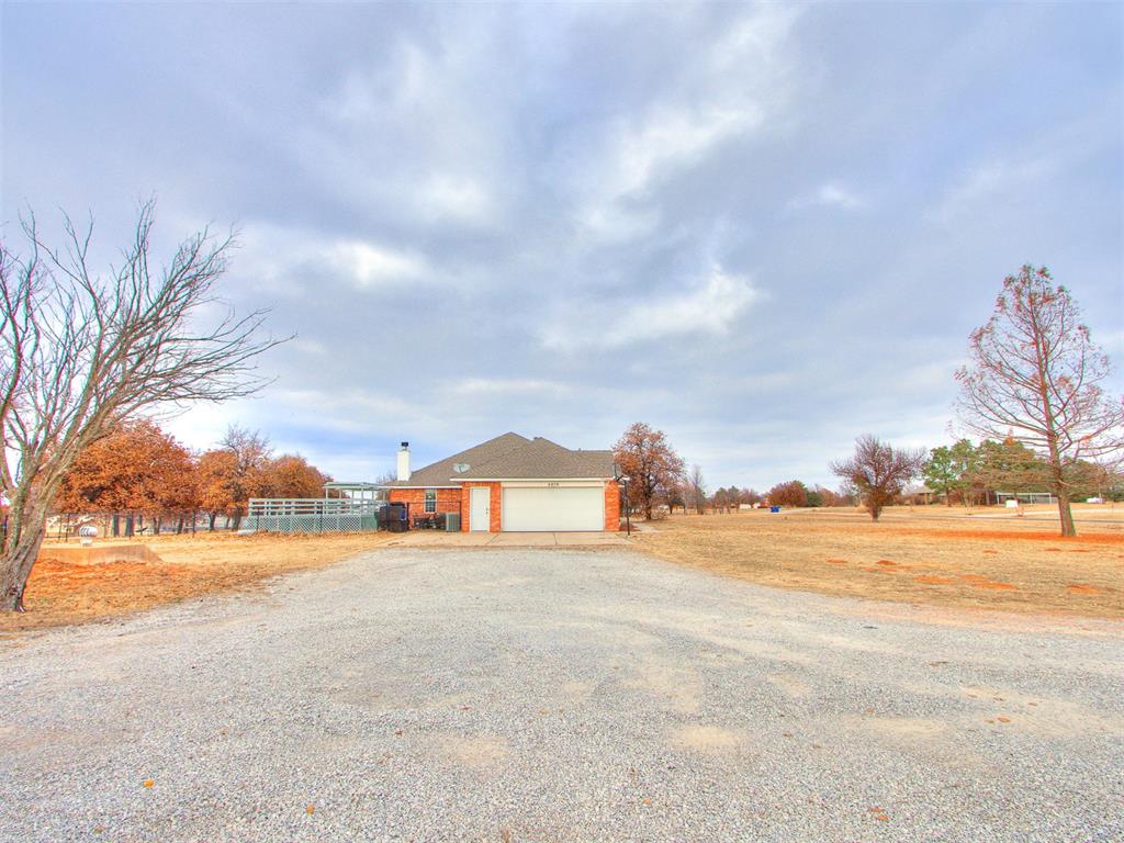 Tessa Hood Realtor – Rear exterior with garage and long gravel driveway on 2.5 acres at 5879 Mockingbird Ln, Blanchard Oklahoma