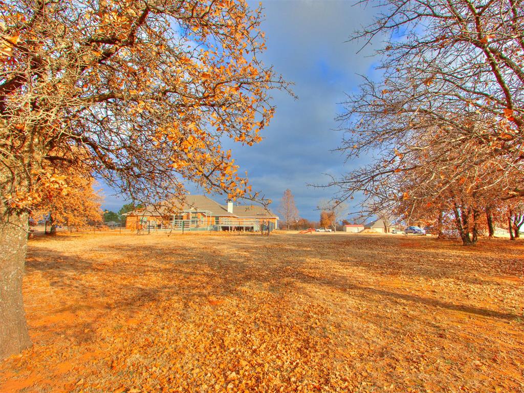 Tessa Hood Realtor – Spacious backyard with mature trees and open acreage at 5879 Mockingbird Ln, Blanchard Oklahoma