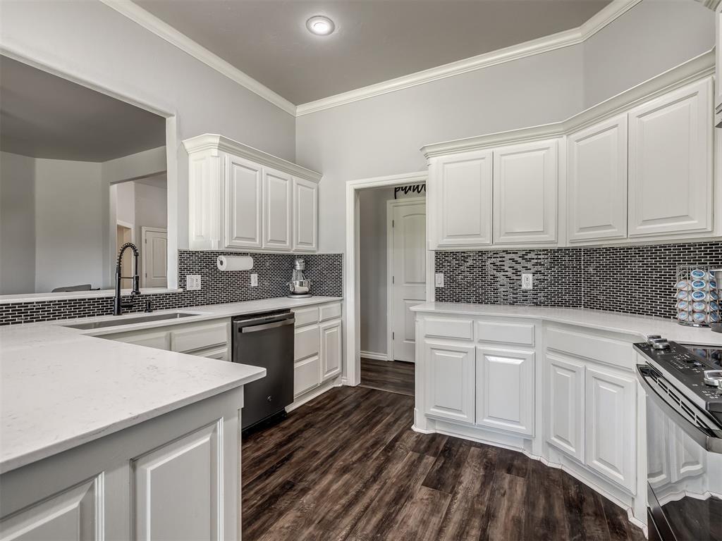 Tessa Hood Realtor – Kitchen with white cabinets, quartz island, and pantry access at 6910 Rolling Meadows Dr, Tuttle Oklahoma