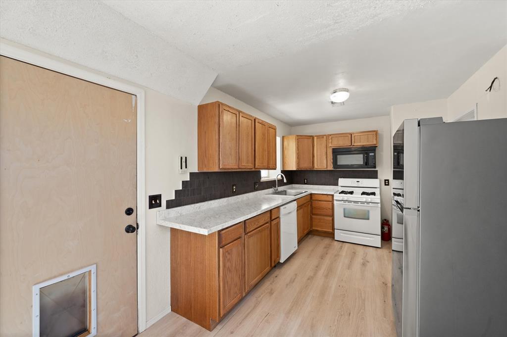 Tessa Hood Realtor – Kitchen with oak cabinets, tile backsplash, and updated countertops at 2028 Rose Court, Norman Oklahoma