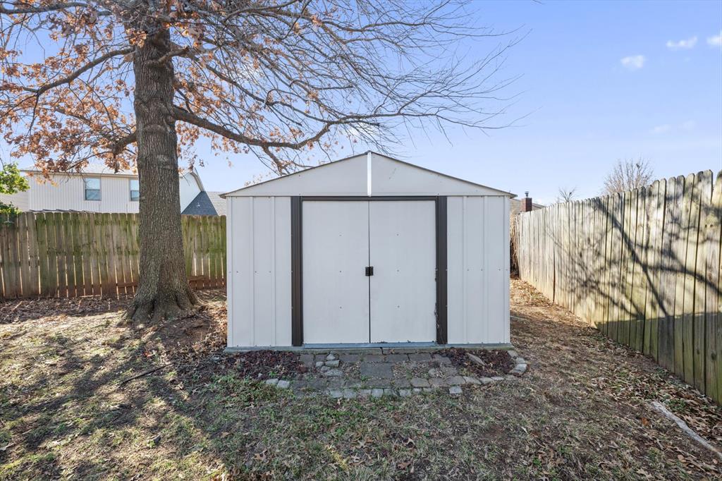 Tessa Hood Realtor – Backyard with storage shed and mature shade tree at 2028 Rose Court, Norman Oklahoma
