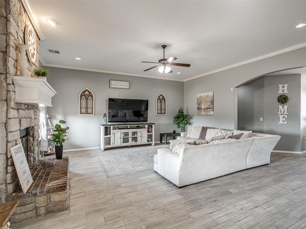 Tessa Hood Realtor – Living room with full stone fireplace and crown molding at 5708 SE 148th St, Oklahoma City OK