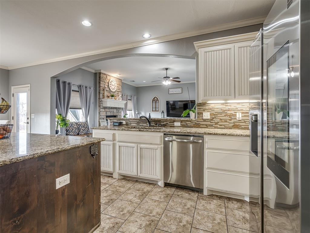 Tessa Hood Realtor – Kitchen view toward living room and stone fireplace at 5708 SE 148th St, Oklahoma City OK