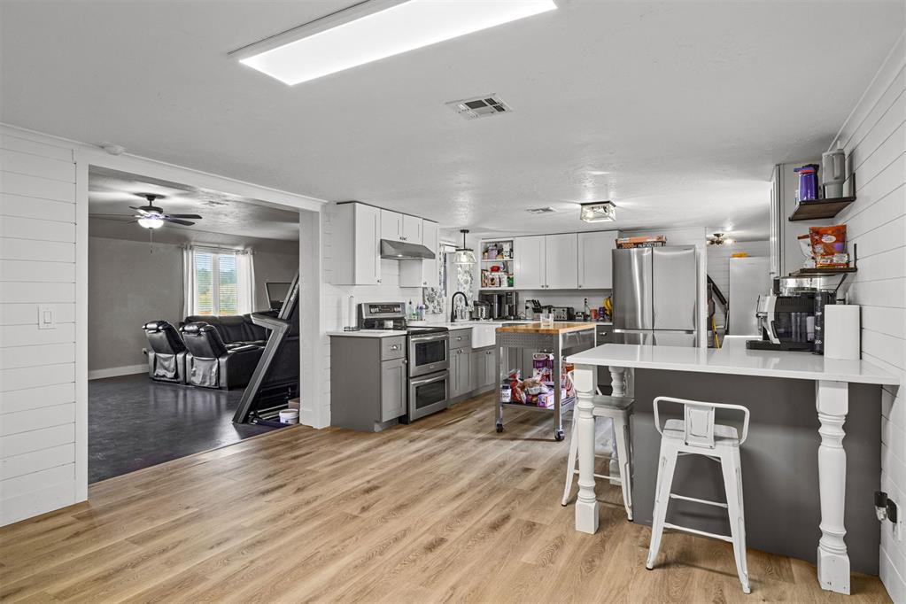 Tessa Hood Realtor – Kitchen with gray cabinetry, stainless appliances, and farmhouse sink at 21063 State Hwy 76, Blanchard Oklahoma